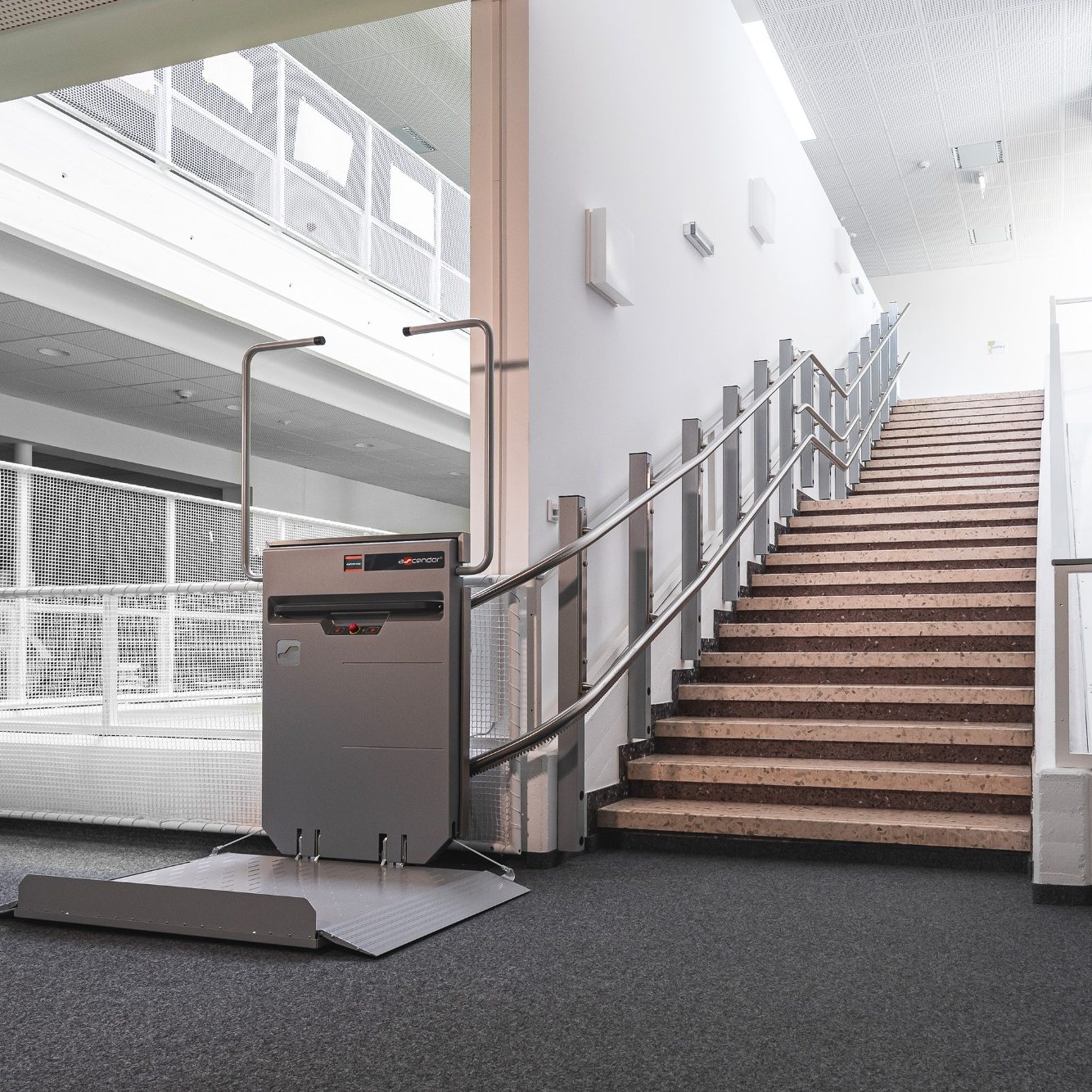Treppenlift neben einer Treppe in einem modernen Gebäude.