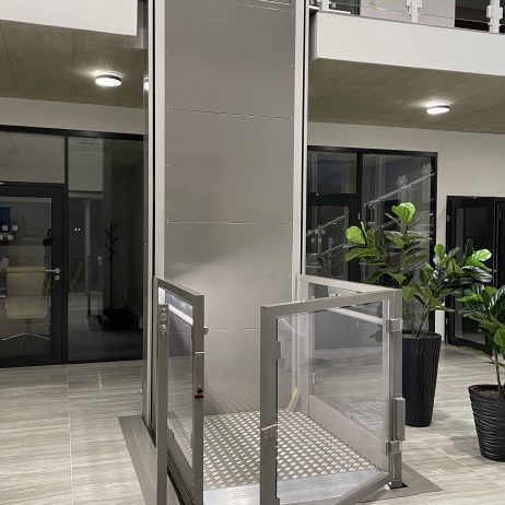 Aufzug mit gläsernen Türen in modernem Innenraum, umgeben von Pflanzen in herford.